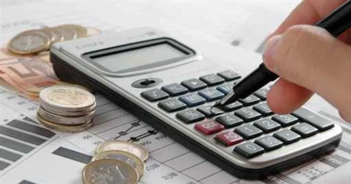 صورة توضح استخدام آلة حاسبة مع عملات نقدية فوق أوراق مالية للتعبير عن الحسابات البنكية والمراجعة المالية وإدارة الأموال