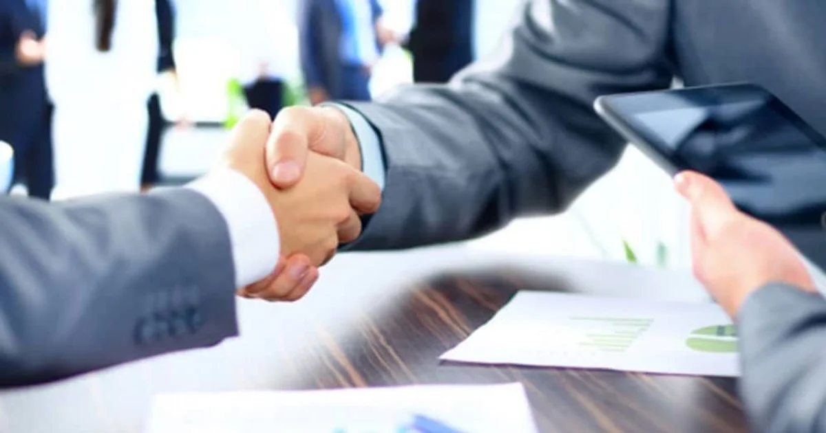 اتفاق شراكة بين رجال أعمال يوضح أهمية اختيار الشكل القانوني المناسب وفهم الفرق بين شركات الأشخاص و شركات الأموال قبل تأسيس الشركة.