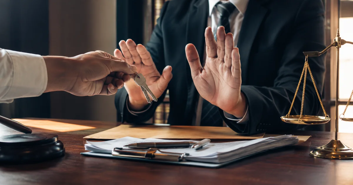 شخص يرفض استلام أو رد مفاتيح فوق أوراق قانونية على مكتب محاماة مع ظهور ميزان العدالة، في دلالة على النزاع حول الشيء المسلم على سبيل الأمانة.