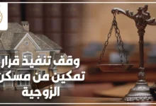 وقف تنفيذ قرار تمكين من مسكن الزوجية مع ميزان العدالة ومجسم منزل.